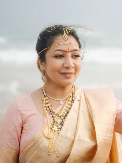 A bride on the beach, the wind gently blowing through her hair. This portrait captures a moment of peace and contentment against the backdrop of the sea.