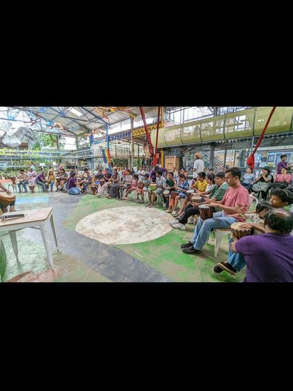 Participants seated in a circle for the inclusive drum session. This event, led by a master Guinean ensemble, created a space for connection, communication, and creativity through rhythm.