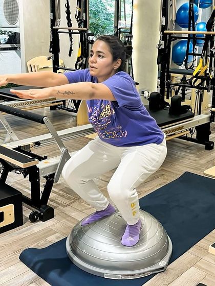 Finding balance on the BOSU ball. This squat requires deep core engagement and focus to maintain stability and proper alignment.