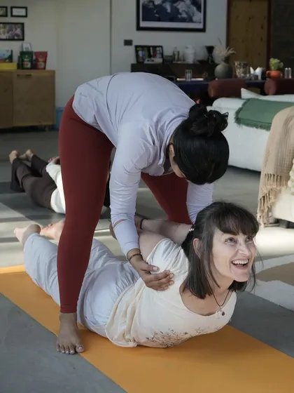 A smile during a deep backbend says it all. Here, I'm assisting a student in Salabhasana (Locust Pose), helping her to open her chest and shoulders while feeling supported and safe.