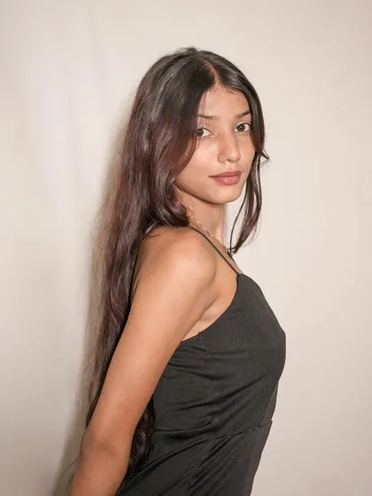 A classic portrait capturing the model's direct gaze and the simple, alluring style of the black dress.
