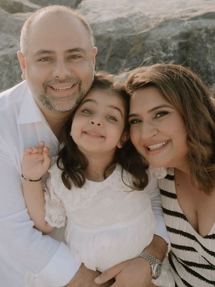 A beautiful family portrait. Mama bear, papa bear, and the big sister eagerly waiting to meet the newest addition to their family. Her makeup is natural and radiant for this beachside family shoot.