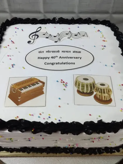 A 40th-anniversary cake for a music group. This photo cake features images of a harmonium and tabla, celebrating their passion for music.