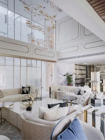 This double-height living room was planned to maximize visual connection and open sightlines. The wall paneling adds a classical touch to the modern space, while the layered textures and ample sunlight create a welcoming environment for conversation and relaxation.