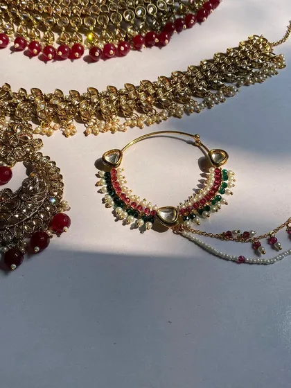 A close-up of a multi-color beaded nath, part of a full bridal set but also available for individual rental.