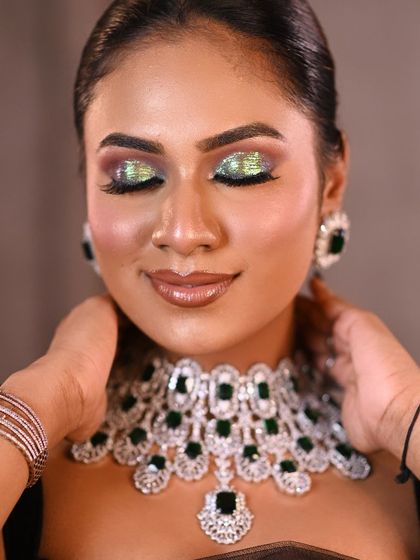 A vibrant and glamorous beauty shot designed to showcase a bold, glittery eye makeup look. The close-up framing allows every detail of the MUA's work to shine.
