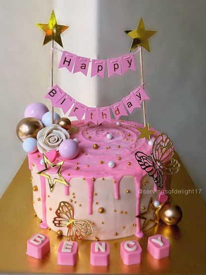 A beautiful pink drip cake personalized with the name "Bency." The combination of a birthday banner, flowers, and butterflies makes it extra special.