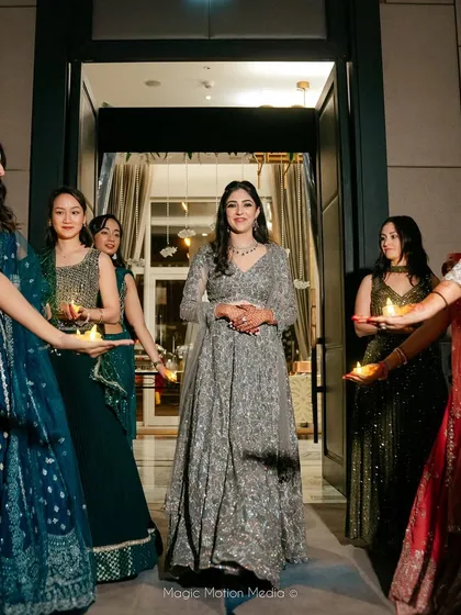 A beautiful shot of our bride making her entrance, welcomed by her bridesmaids holding candles. We help stage these moments for maximum emotional and visual impact.