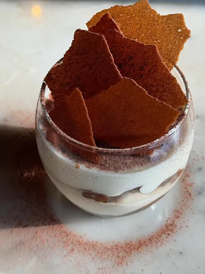 A beautifully composed shot of our Tiramisu, with a swirl of cocoa dust on the plate.