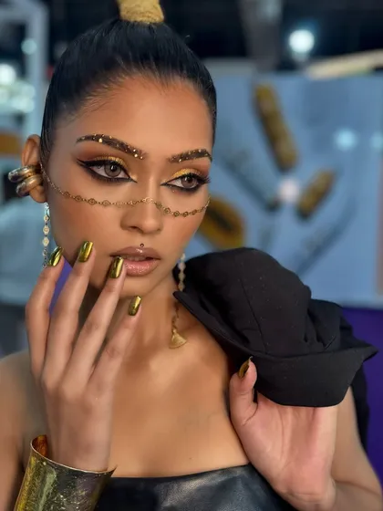 This is where makeup becomes art. A bold, editorial look I created for a show, featuring sharp graphic eyeliner, gold glitter accents, and matching metallic gold nails. This is the kind of advanced, creative work we explore in my professional course.