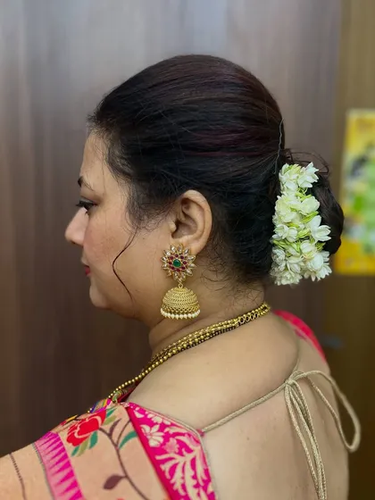 The profile view shows how neatly the hair is styled into a bun, providing a perfect base for the gajra.