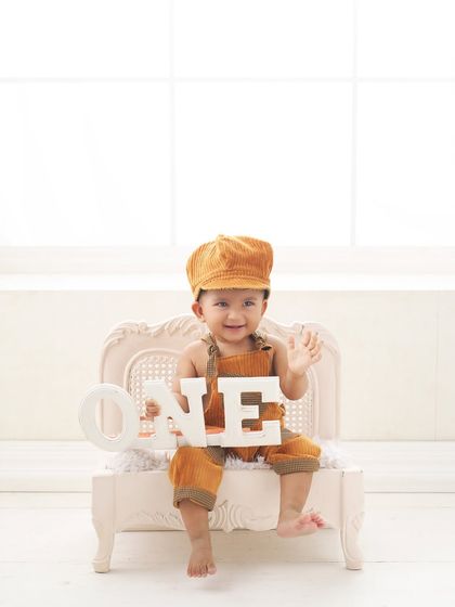 A bright and simple first birthday portrait. This clean, high-key setup puts all the focus on your smiling baby and the celebration of their first year.