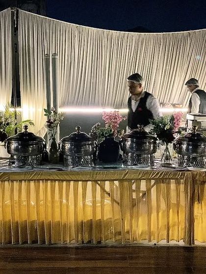 My team setting up for an evening event in DLF Phase 4. The combination of warm lighting and professional staff ensures a welcoming atmosphere as guests arrive.