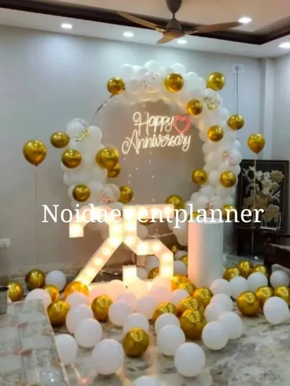 Celebrate your milestones with our anniversary decor, like this 25th anniversary setup with marquee numbers and a 'Happy Anniversary' neon sign against a white and gold balloon arch.