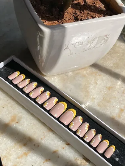 The sunflower press-on nail set in its packaging, ready to be gifted or worn. I can customize the length and shape, from short and round to long and almond.