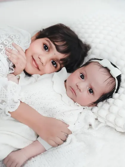 The bond between siblings is pure magic. I focus on capturing that gentle, protective love, like this quiet moment between an older sister and her new baby sibling.