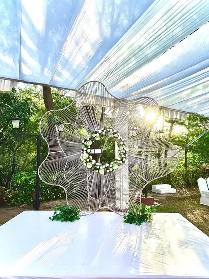 A unique, flower-shaped backdrop made of intricate thread work, creating an artistic and delicate photo opportunity.