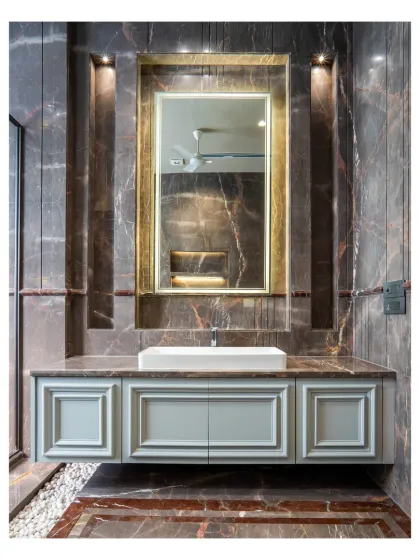 A close-up of the vanity in the dark marble bathroom. The neo-classical style of the cabinet doors contrasts beautifully with the modern vessel sink and the dramatic, veined marble.