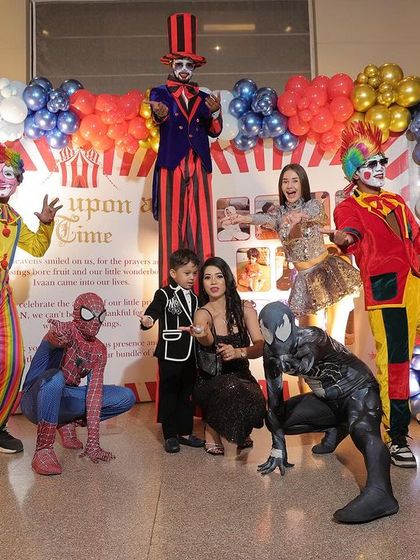 The birthday boy and his family posing with the full cast of entertainers at their carnival themed party.