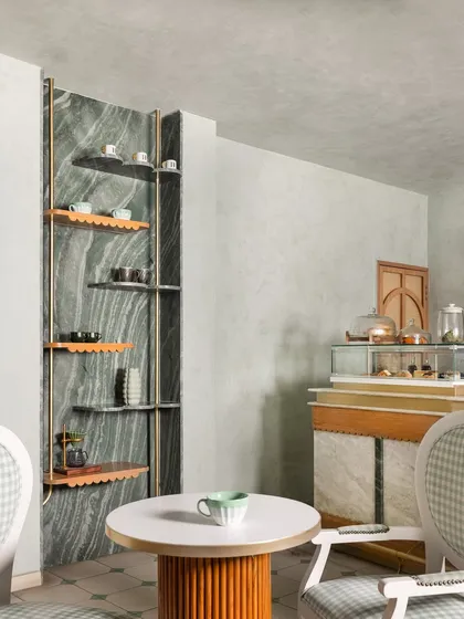 A wider view of the shelving unit, showing how it acts as a sculptural feature against the dramatic green marble wall.
