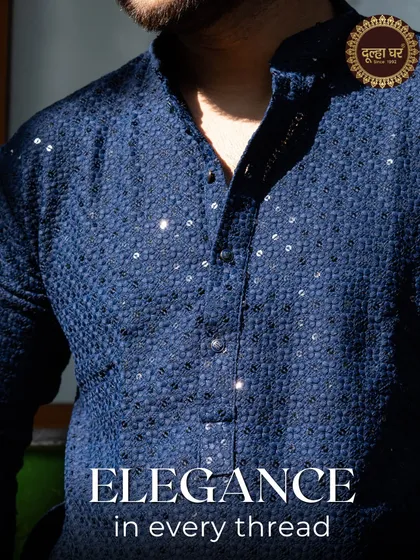 Elegance in every thread. A close-up of a navy blue kurta, showing the intricate texture and shimmering sequins.