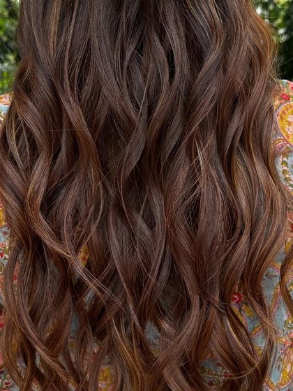 Getting her holiday-ready with a rich blend of copper and caramel highlights. This warm, wavy style is perfect for a festive getaway.
