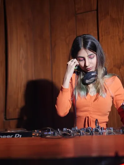 Adjusting my headphones to cue up the next track. This is a classic DJ pose, capturing a moment of intense concentration.