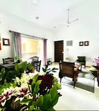 A view of the open-plan living and dining area. The high ceilings create a wonderful sense of space and light, making it an ideal spot for everyone to gather, relax, or share a meal after a day at the beach.