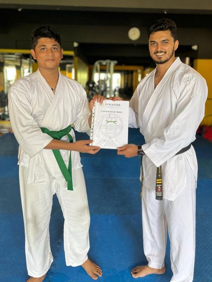 Presenting a certificate of promotion to a student who has successfully passed his green belt test. Hard work pays off.