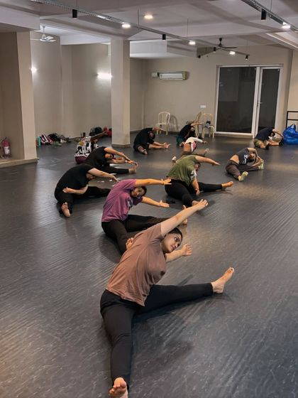Our adult students work on their seated side stretches. Flexibility is a journey, and we focus on consistent, safe practice to achieve long-term results.
