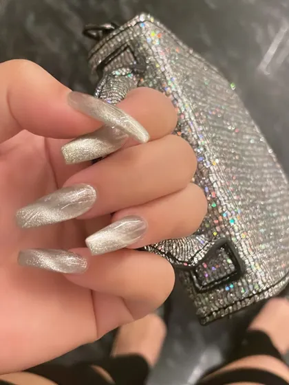 A chic and modern cat-eye effect in silver. Paired with a sparkly bag, these nails are the perfect accessory for a glamorous night out.