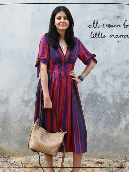 Tulika holding the All Woven Bronze Little Namrata as a grab bag, demonstrating its multiple carrying options.