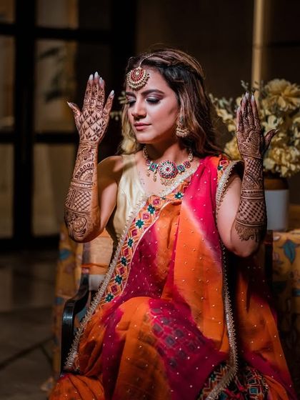 A bride showcasing her beautiful Mehendi design. The dramatic lighting creates a moody and artistic portrait.