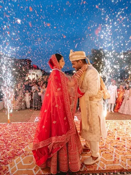 The magical moment of the varmala exchange, illuminated by a shower of fireworks. This is the kind of grand, unforgettable shot that defines a wedding celebration.