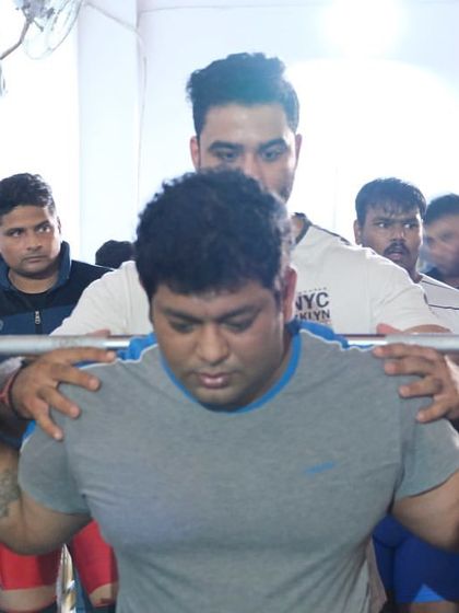 Getting set up for a heavy squat with my spotter. Trust in your team is crucial on the platform.