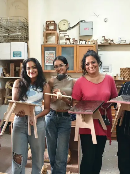 A group of five women who spent their Saturday learning woodworking. They each built a small, practical stool to take home.