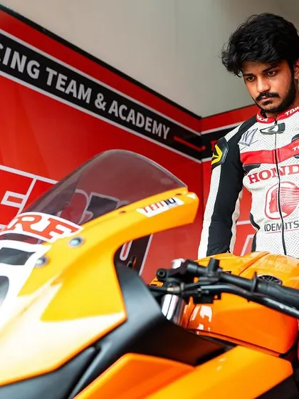 A moment of calm before the storm. A rider stands with his bike in the Ten10 Racing garage, ready for the INMRC race. The professional setup of our pit area reflects our commitment to excellence.