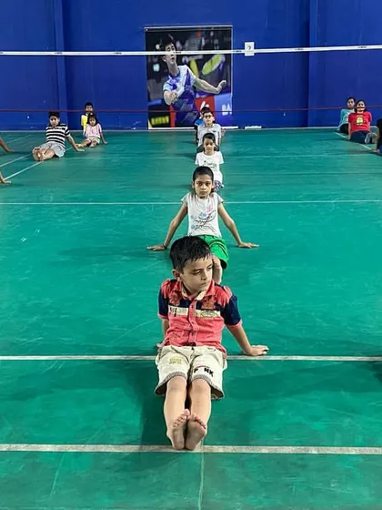 Younger players participating in a stretching exercise. We teach the importance of flexibility and proper body mechanics from an early age.
