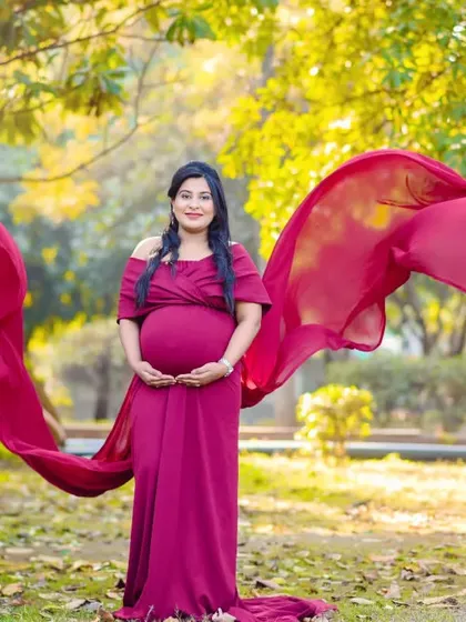 Another beautiful shot showcasing the flowing fabric of a maternity gown. The movement adds a lovely, dynamic element to this outdoor portrait.