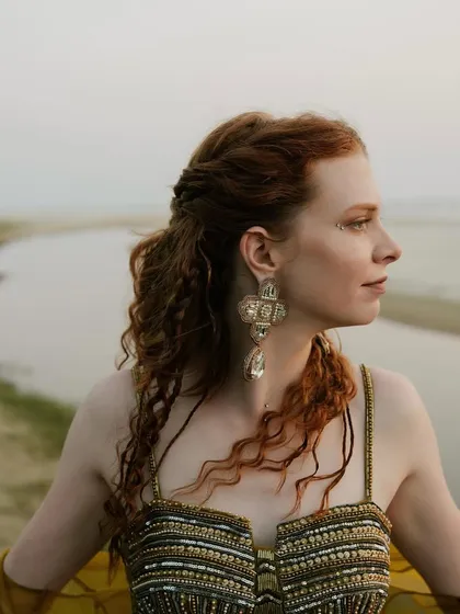 A close-up of the bride's sundowner look. Her seashell-inspired embroidered corset blouse and antique-style earrings were perfect for the beachy, bohemian theme.