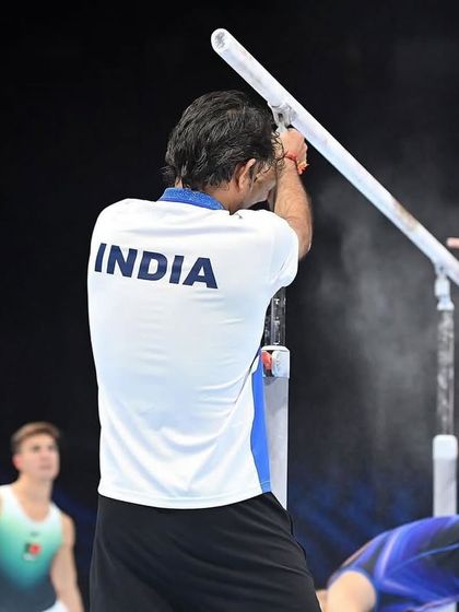 A coach's perspective at the World Championships. Here, I am chalking the parallel bars for our athlete, a crucial part of the pre-routine preparation.