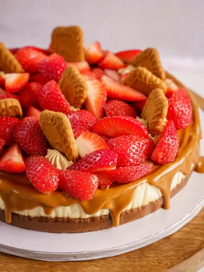 This strawberry and Biscoff cheesecake is a visual treat. The composition draws your eye to the generous toppings and the caramel drip. It’s a perfect shot for a bakery's menu or Instagram feed, promising a rich and fruity dessert experience.