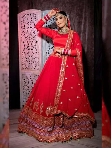 A full-length shot of a bride in a classic red lehenga, perfect for a portfolio.