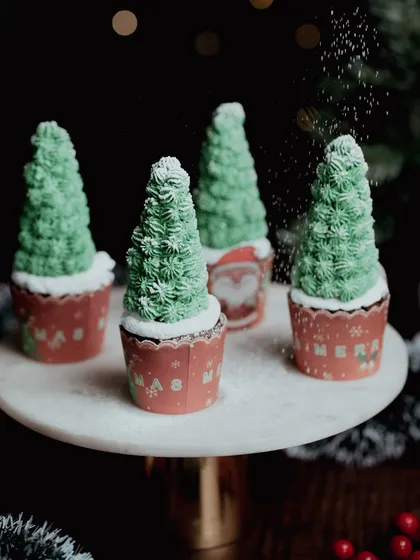 Christmas tree-shaped cupcakes with a sprinkle of powdered sugar "snow". This playful and creative shot is perfect for capturing the holiday spirit.