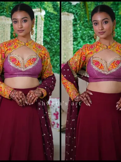 A beautiful shot of a client with her dark mehendi stain. The design is a simple yet elegant cutwork pattern with a lotus motif, perfect for a sangeet or reception look.