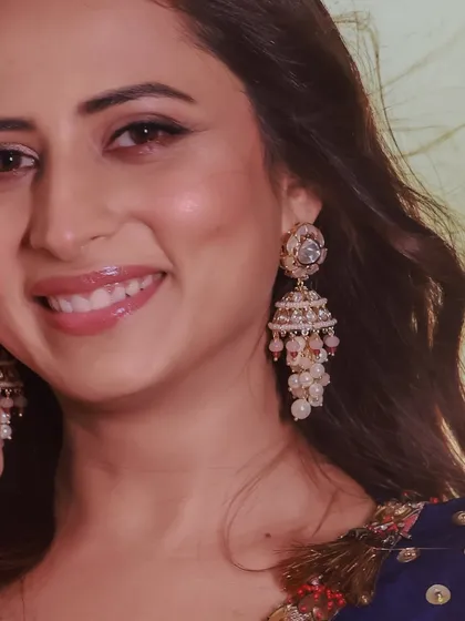 A close-up of Sargun Mehta, showing the intricate detail and delicate pearl work on her jhumka earrings.