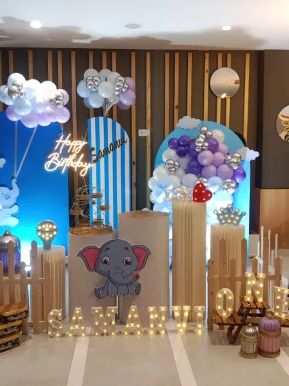 A sweet elephant-themed first birthday party. I used a soft blue and purple color scheme with cute elephant cutouts, balloon clouds, and a picket fence to create a gentle and adorable atmosphere.