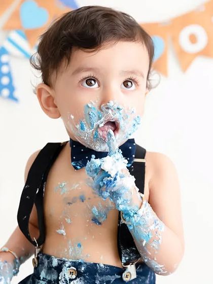 A close-up of the messy fun from a classic blue-themed cake smash session.