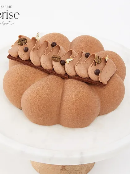 My Mochaccino entremet, for those who love the bittersweet pairing of coffee and chocolate. The piped topping is dusted with cocoa and decorated with coffee beans.