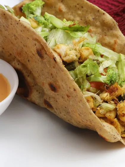 For restaurants and cloud kitchens, appetite appeal is everything. This close-up of a freshly made wrap focuses on the texture of the bread, the crispness of the lettuce, and the savory filling, creating a mouthwatering image perfect for menus and delivery apps.